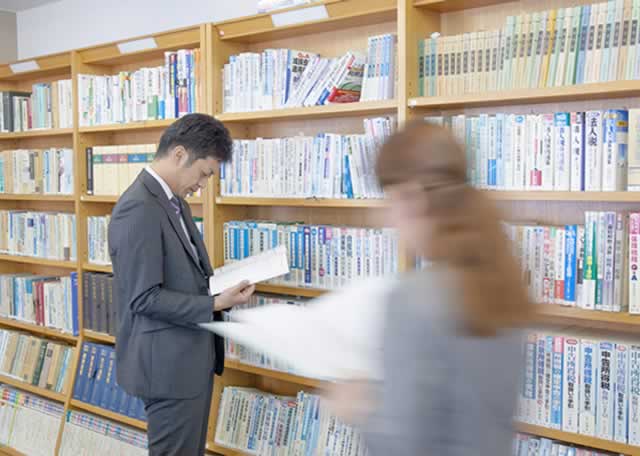 オフィスで参考資料を読むスタッフ