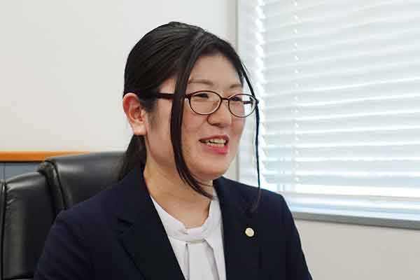 参考書籍を読む女性スタッフ